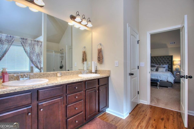 bathroom with hardwood / wood-style floors, vanity, and walk in shower