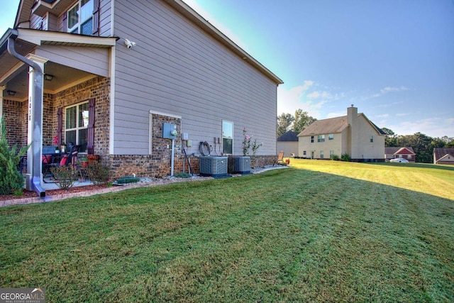 view of home's exterior with a yard and central AC