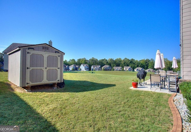 view of yard featuring a storage unit and a patio