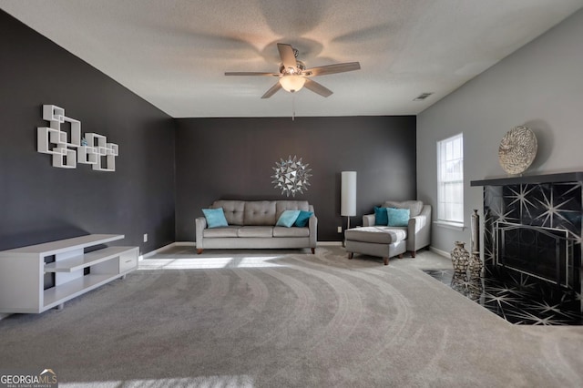 carpeted living room with a textured ceiling and ceiling fan