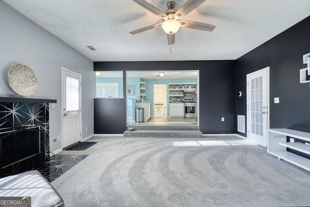 living room featuring ceiling fan and dark colored carpet