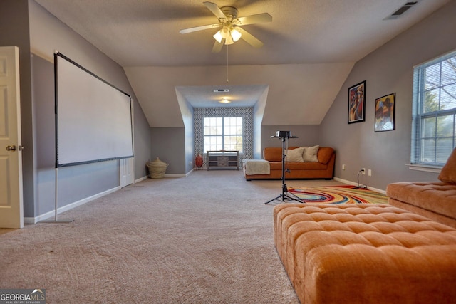 cinema room with vaulted ceiling, ceiling fan, and light carpet