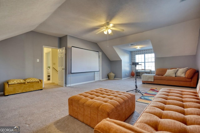 carpeted home theater room with lofted ceiling, a textured ceiling, and ceiling fan