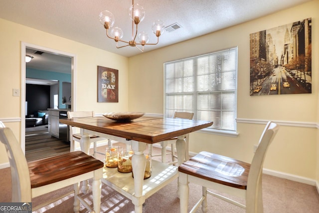 dining room with a healthy amount of sunlight, a textured ceiling, a chandelier, and carpet flooring