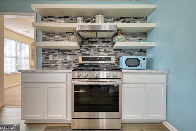 kitchen featuring light hardwood / wood-style floors, stainless steel range, white cabinetry, and decorative backsplash