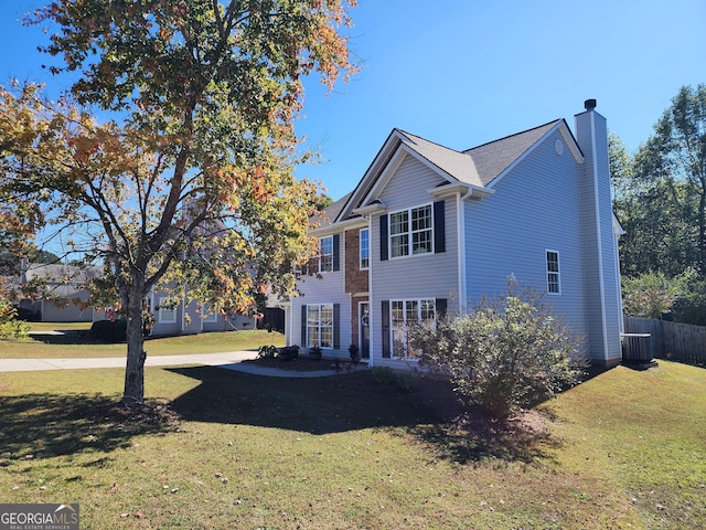 view of front facade featuring a front yard and central AC