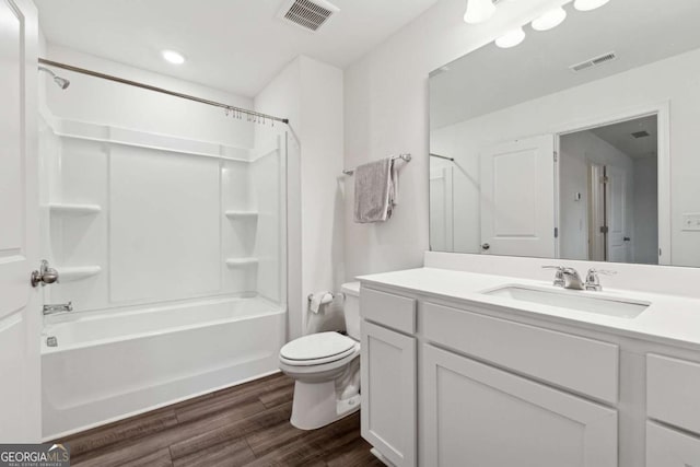 full bathroom featuring shower / washtub combination, hardwood / wood-style floors, vanity, and toilet