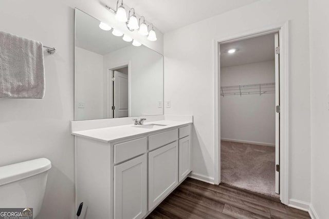 bathroom with wood-type flooring, vanity, and toilet