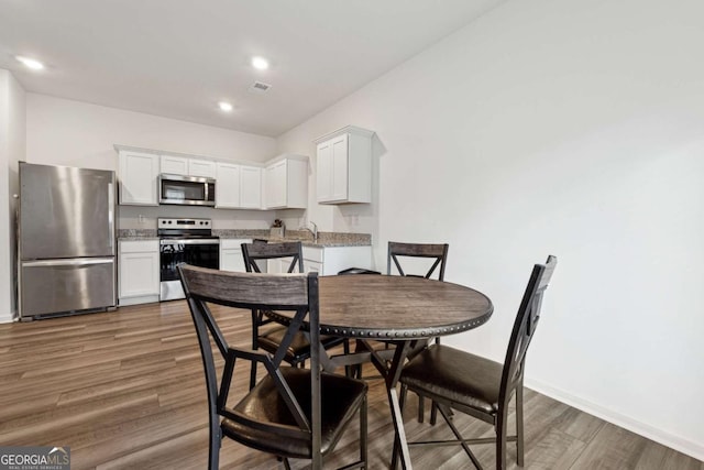 dining area featuring dark hardwood / wood-style floors and sink