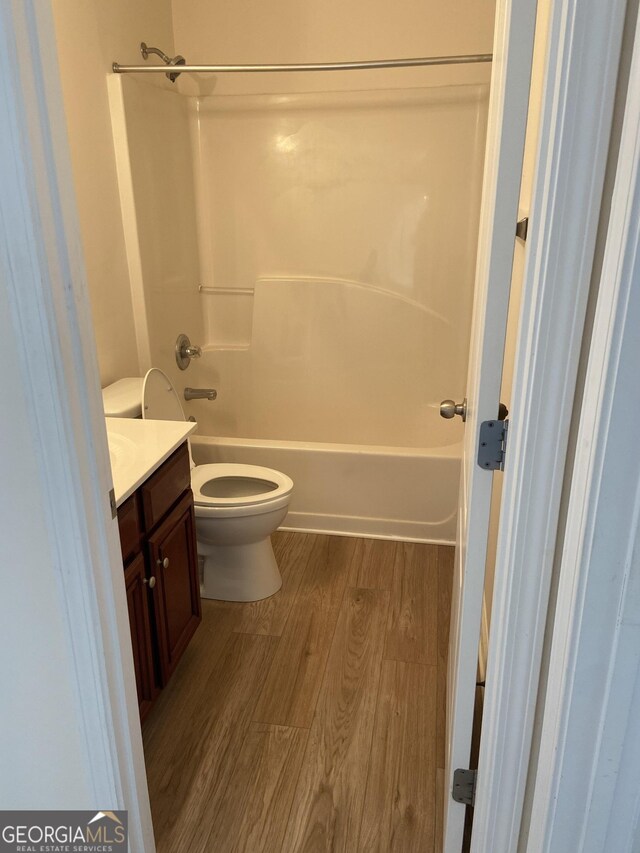 full bathroom featuring hardwood / wood-style flooring, bathtub / shower combination, toilet, and vanity