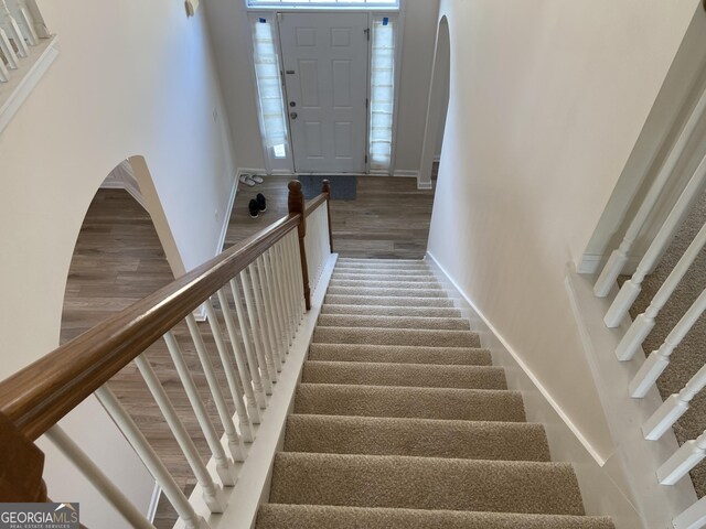 stairway featuring a wealth of natural light and hardwood / wood-style flooring