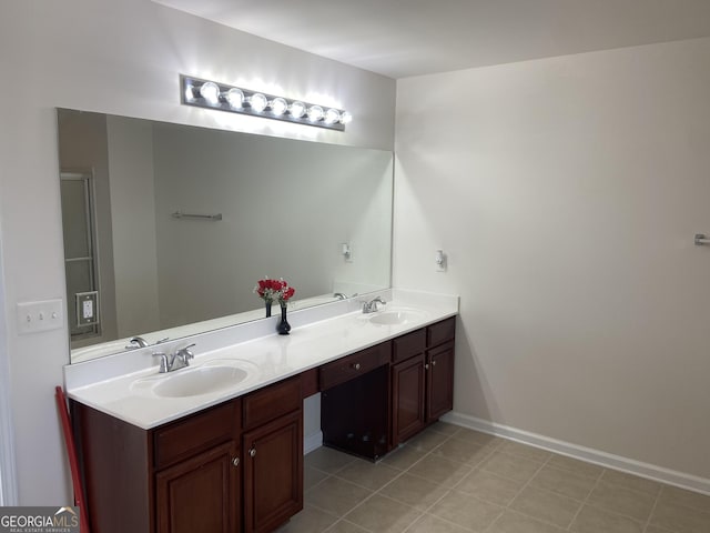 bathroom with double vanity, tile patterned flooring, a sink, and baseboards