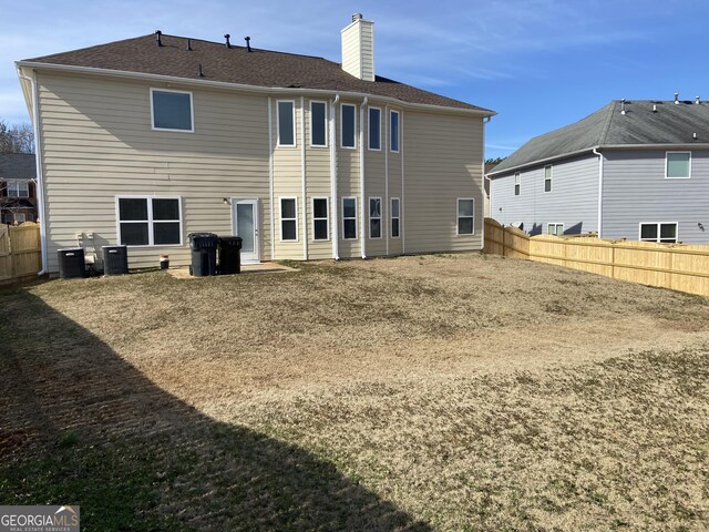 back of property featuring a yard and central air condition unit