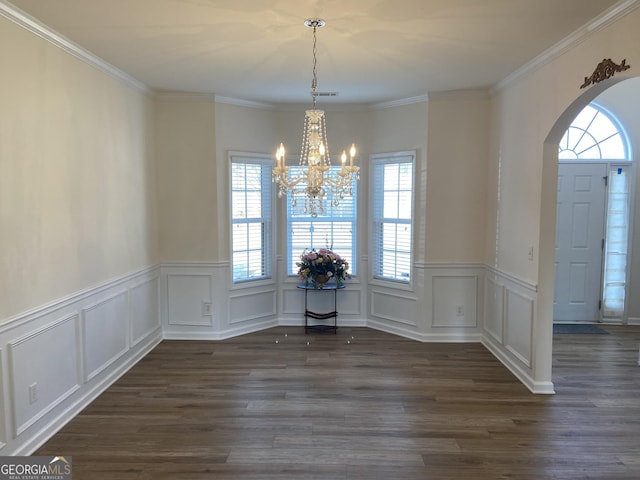 unfurnished dining area featuring arched walkways, dark wood-style flooring, visible vents, and an inviting chandelier