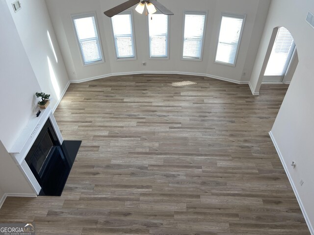 unfurnished living room with dark wood-type flooring and ceiling fan