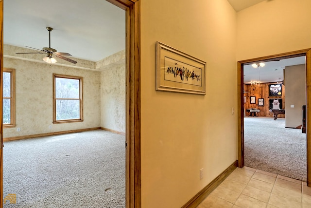 hallway with light colored carpet and wooden walls