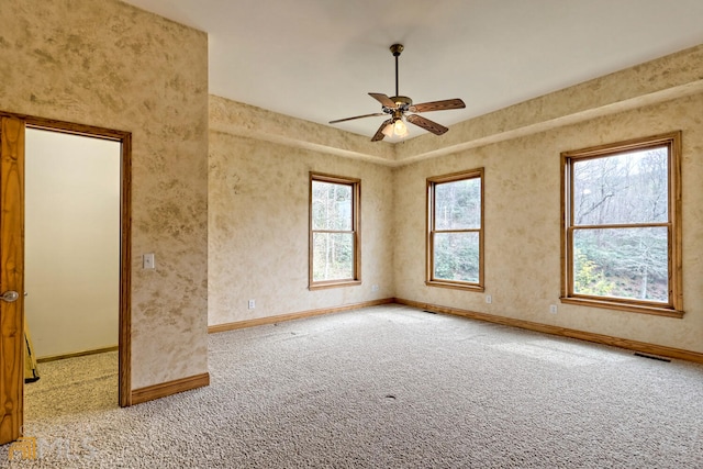 empty room featuring light colored carpet, plenty of natural light, and ceiling fan