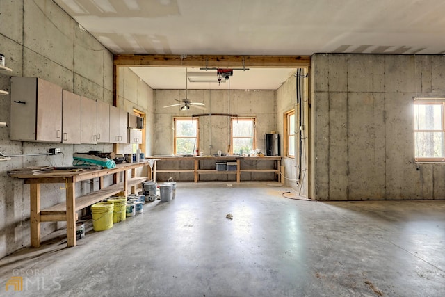 interior space featuring a workshop area, ceiling fan, a healthy amount of sunlight, and beam ceiling