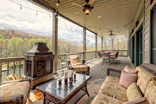 wooden terrace featuring an outdoor living space with a fireplace and ceiling fan