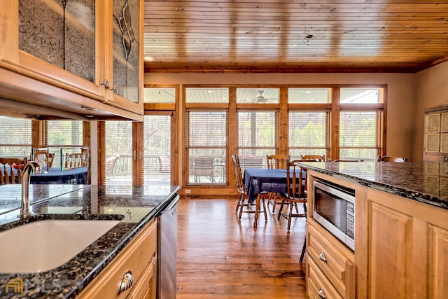 kitchen with wooden ceiling, dark stone counters, sink, light hardwood / wood-style flooring, and appliances with stainless steel finishes