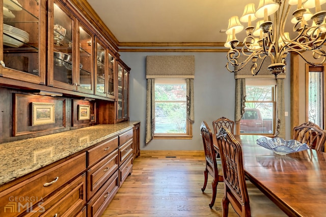 dining area with a chandelier, light hardwood / wood-style flooring, and crown molding