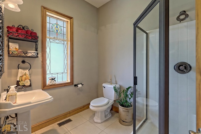 bathroom featuring tile patterned floors, sink, toilet, and walk in shower