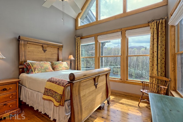 bedroom featuring ceiling fan, vaulted ceiling, and light hardwood / wood-style flooring