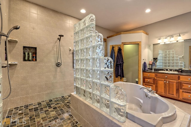 bathroom featuring a tile shower, tile patterned floors, vanity, and toilet