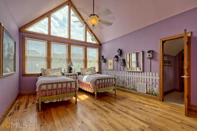 bedroom featuring ceiling fan, lofted ceiling, and light hardwood / wood-style flooring