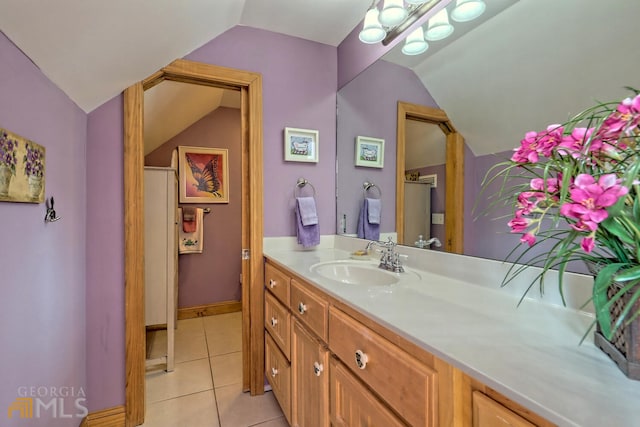 bathroom featuring tile patterned flooring, vanity, and lofted ceiling