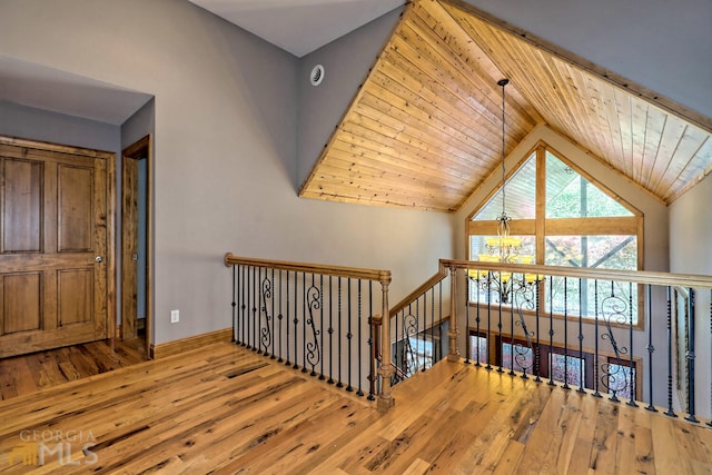 stairway featuring wood ceiling, a notable chandelier, and hardwood / wood-style flooring