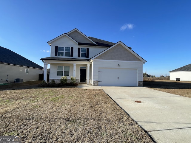 view of front of property with a garage, cooling unit, and a front yard