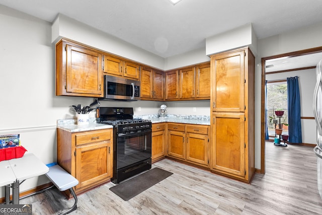 kitchen with black range with gas cooktop and light wood-type flooring