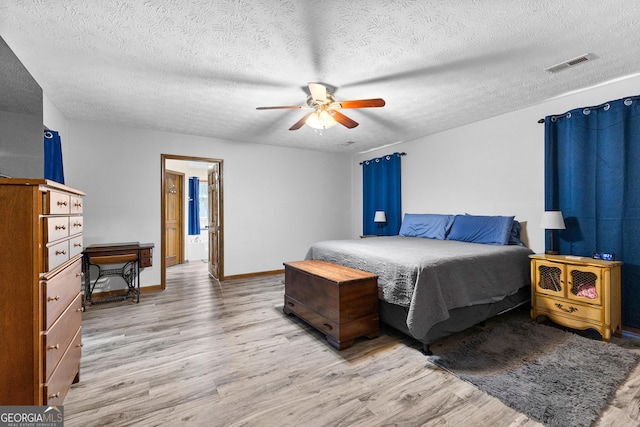 bedroom featuring ceiling fan, a textured ceiling, and light hardwood / wood-style flooring