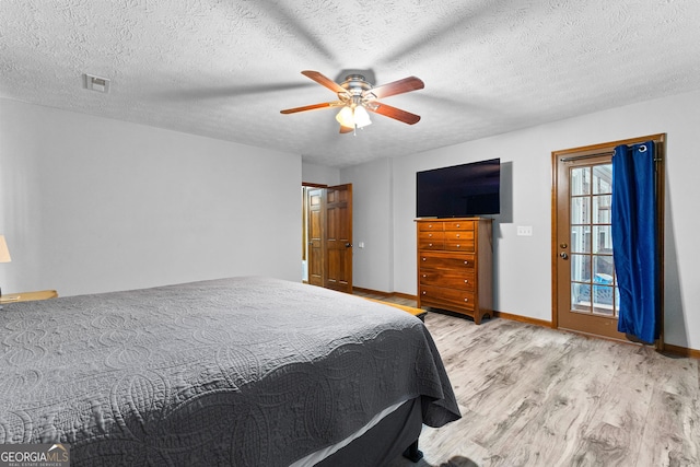 bedroom featuring light wood-type flooring, a textured ceiling, and ceiling fan