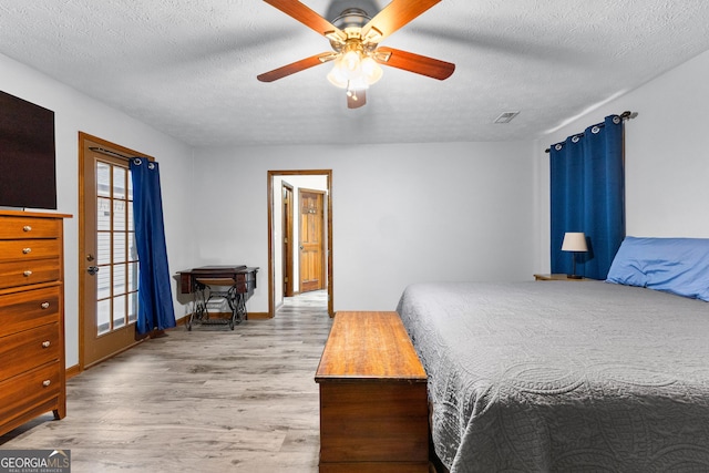 bedroom with ceiling fan, light wood-type flooring, and a textured ceiling