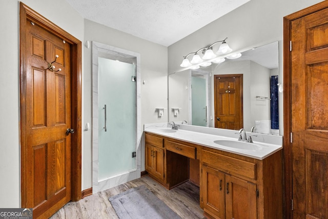 bathroom with walk in shower, vanity, a textured ceiling, and hardwood / wood-style flooring