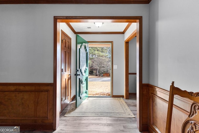 doorway to outside featuring light hardwood / wood-style floors and ornamental molding