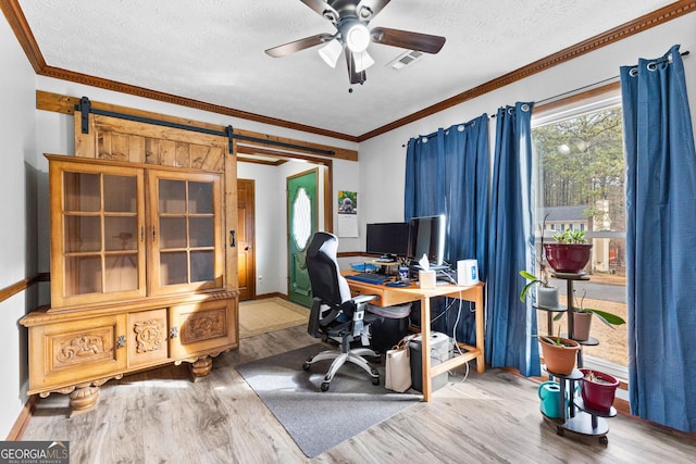 office with hardwood / wood-style floors, crown molding, ceiling fan, a barn door, and a textured ceiling