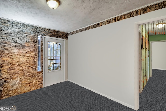 empty room featuring carpet and a textured ceiling