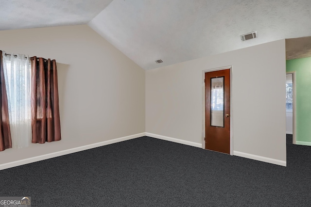 empty room featuring carpet, plenty of natural light, and vaulted ceiling