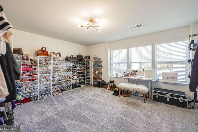 living area with an inviting chandelier and carpet flooring