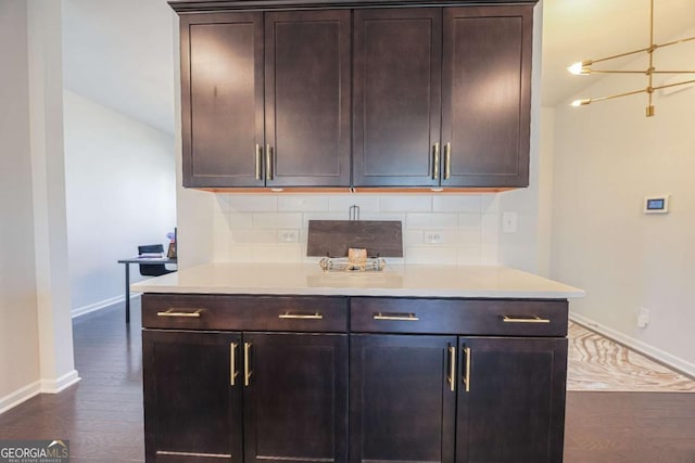 kitchen with backsplash, dark brown cabinets, and dark wood-type flooring