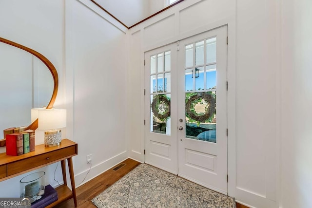 foyer with french doors, wood finished floors, visible vents, and baseboards