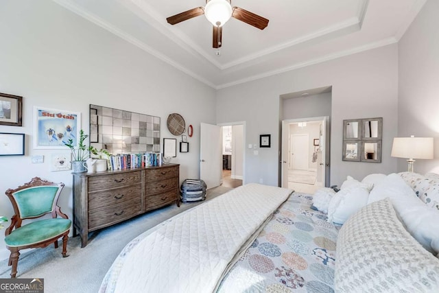 bedroom with a ceiling fan, carpet floors, crown molding, ensuite bathroom, and a raised ceiling