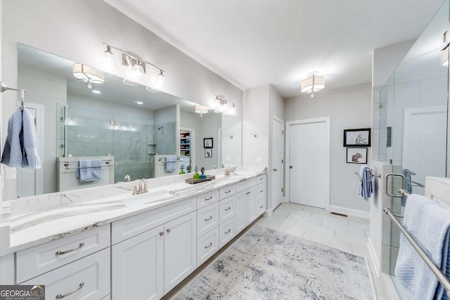 bathroom featuring tile patterned flooring, a sink, baseboards, a shower stall, and double vanity