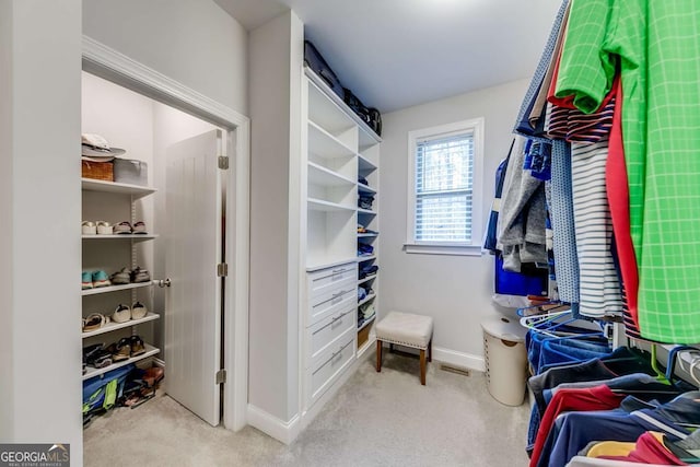 spacious closet featuring light carpet