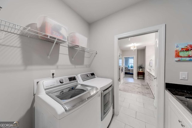 laundry area featuring light tile patterned floors, laundry area, and washer and dryer