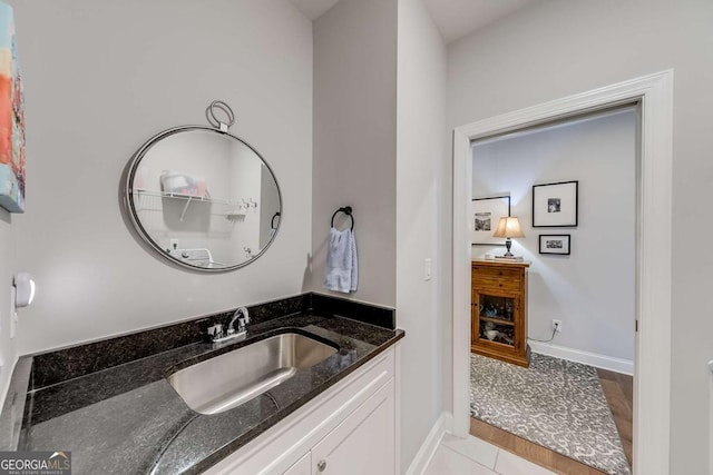 bathroom with tile patterned floors, baseboards, and vanity