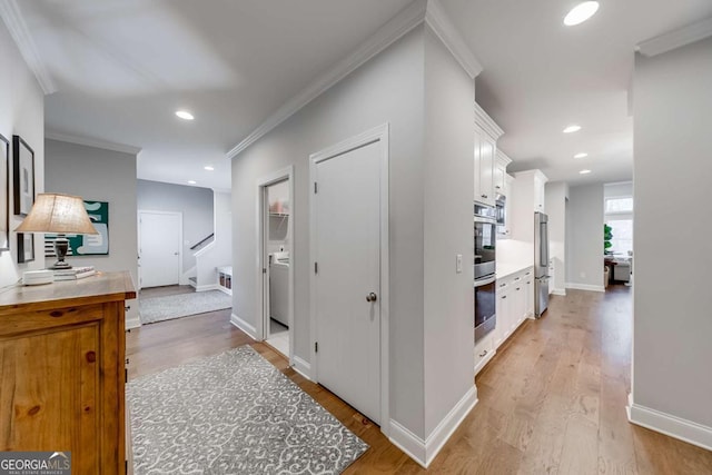 corridor featuring light wood-style flooring, ornamental molding, baseboards, and recessed lighting